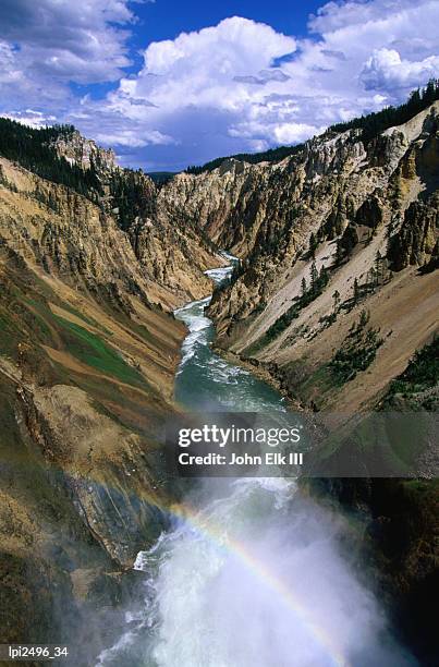 rainbow over river at lower falls, part of yellowstone falls, yellowstone national park, united states of america - cataratas lower falls fotografías e imágenes de stock