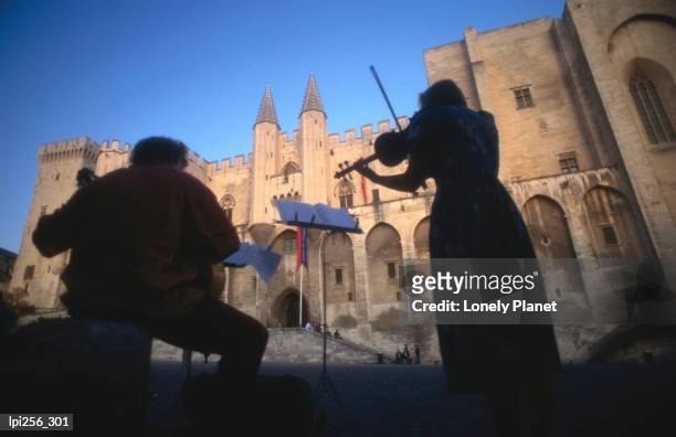 musicians playing in front of palais des papes (palace of the popes), vaucluse. - palais fotografías e imágenes de stock