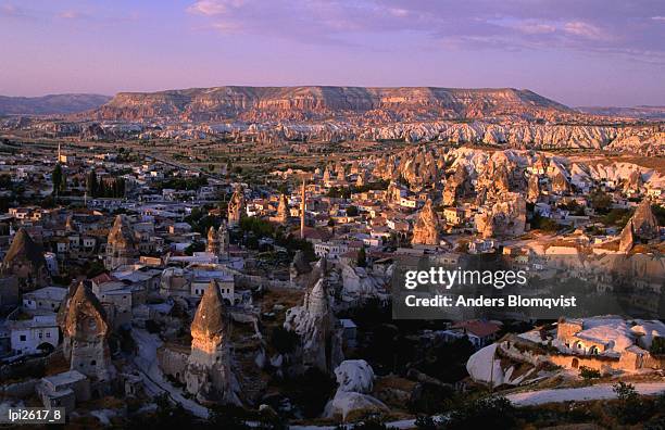 tuff towers and village houses in afternoon light, goreme, nevsehir, turkey, middle east - tufsteenrots stockfoto's en -beelden