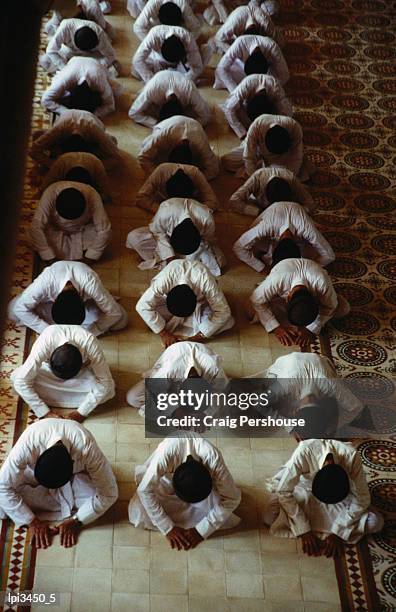 men praying in caodai great temple, tay ninh, vietnam - cao dai temple stock pictures, royalty-free photos & images