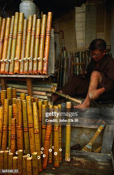 bamboo pipe maker working in his shop in old quarter, side view, hanoi, vietnam - elk stockfoto's en -beelden