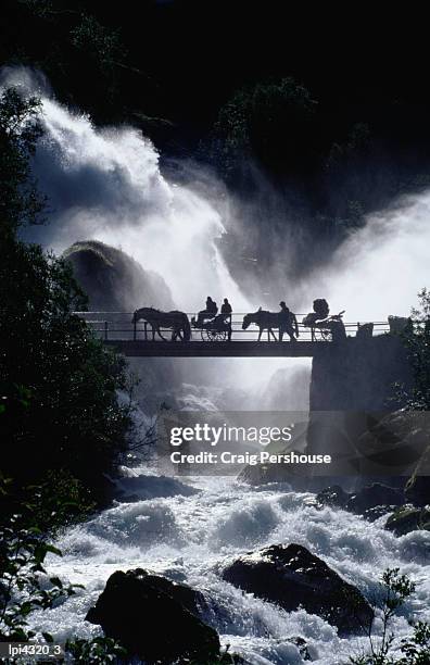 pony carts crossing bridge over waterfall and rapids, briksdal, norway - horse cart ストックフォトと画像