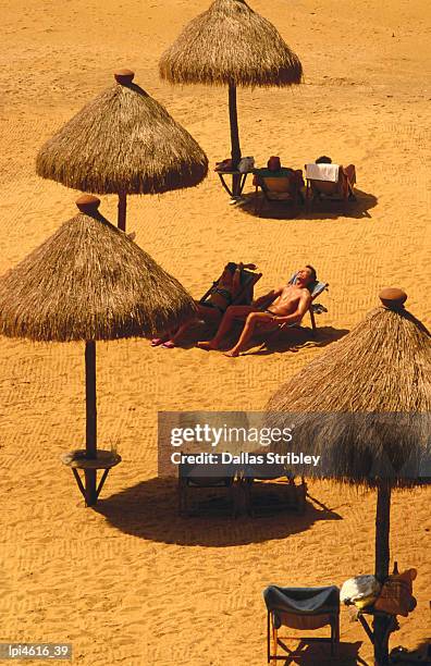 man sunbathing on private beach of mt lavinia hotel. - general economy as central bank of sri lanka looks to contain rising inflation stockfoto's en -beelden