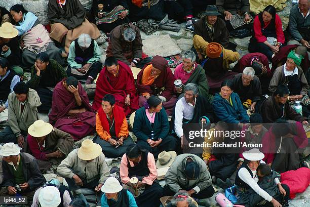 worshippers sitting outside main assembly hall at sera monastery, lhasa, tibet, china, north-east asia - tibet autonomous region stock pictures, royalty-free photos & images