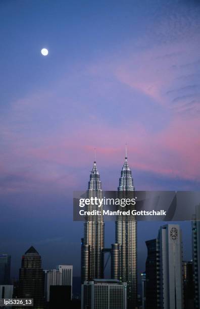 petronas twin towers under moonlight at dusk, kuala lumpur, malaysia - trade center building stock pictures, royalty-free photos & images