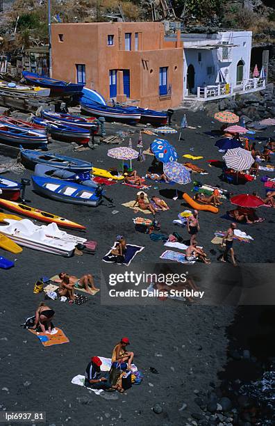 people on black volcanic sand beach. - isole eolie stock pictures, royalty-free photos & images