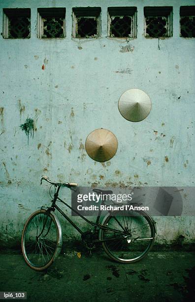 conical hats hang on wall above bicycle in  historic old quarter, hanoi, vietnam, south-east asia - spanish royals host gala dinner in honour of the president of vietnam stockfoto's en -beelden