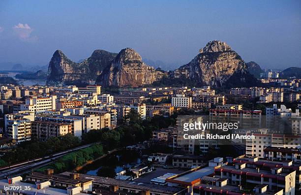 city buildings and limestone karst peaks in the li river, guilin, guangxi, china, north-east asia - karst formation stockfoto's en -beelden
