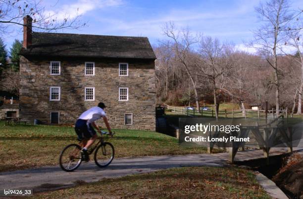 man cycling past building in rock creek park, washington dc, united states of america - lpiowned stock pictures, royalty-free photos & images