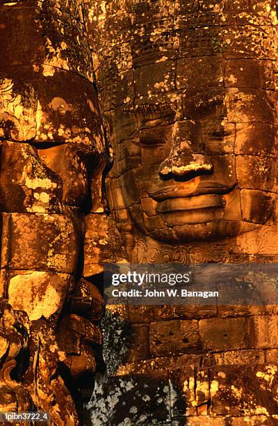 smiling lokesvara bodhisattva (avalokiteshvara) image adorning the bayon temple of angkor thom, angkor, siem reap, cambodia, south-east asia - banagan stock pictures, royalty-free photos & images