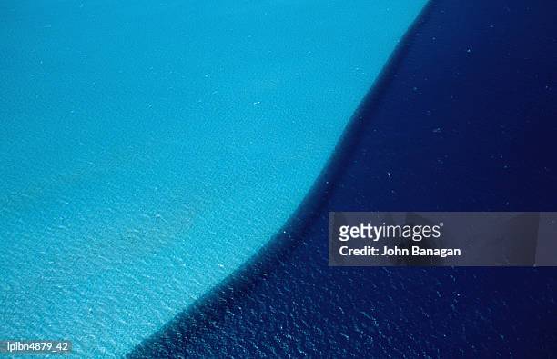ocean water with light blue indicating shallow sandy sea floor and dark blue the deep sand-less floor, coral bay, western australia, australia, australasia - less is more stockfoto's en -beelden
