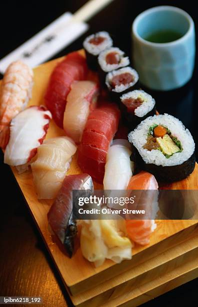 lunch in the sushi restaurant, with two main types of sushi(fresh raw fish slices): nigiri-zushi (served on rice) and maki-zushi (served in a seaweed roll, accompanied by pickled ginger and wasabi (hot, green horseradish)., tokyo, kanto, - nigiri fotografías e imágenes de stock