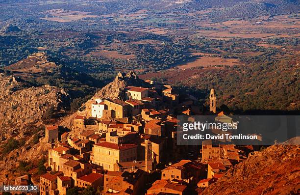 mountain top village bathed in afternoon sunlight., speloncato, corsica, france, europe - balagne stock-fotos und bilder