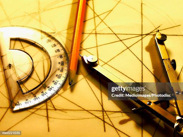 drawing compass, pencil and protractor on sheet of paper with lines, close-up - intersected stock pictures, royalty-free photos & images