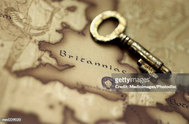antique key on a map - antique stockfoto's en -beelden