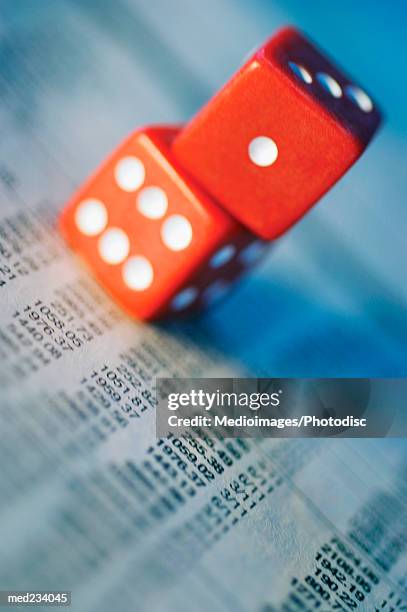 close-up of a pair of dice on a newspaper - share prices of consumer companies pushes dow jones industrials average sharply higher stockfoto's en -beelden