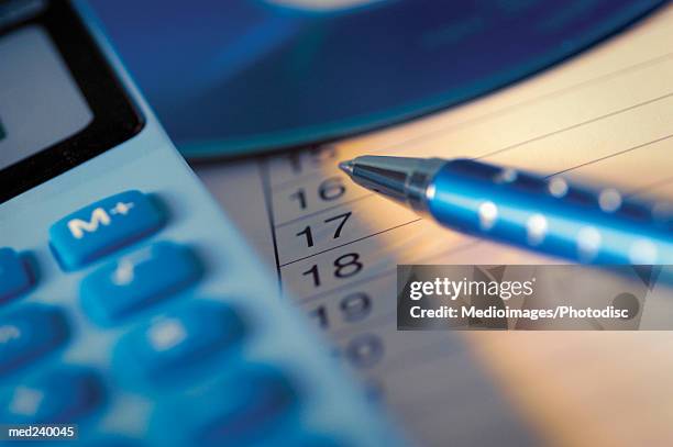 close-up of a ball point pen beside a calculator - intersected stock pictures, royalty-free photos & images