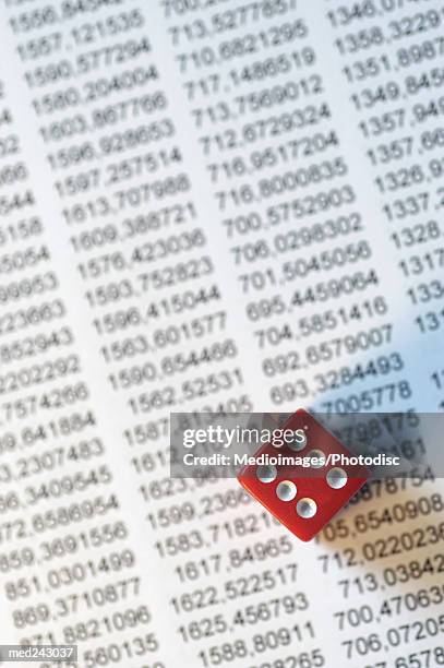 paper with numbers and one red dice, extreme close-up - share prices of consumer companies pushes dow jones industrials average sharply higher stockfoto's en -beelden