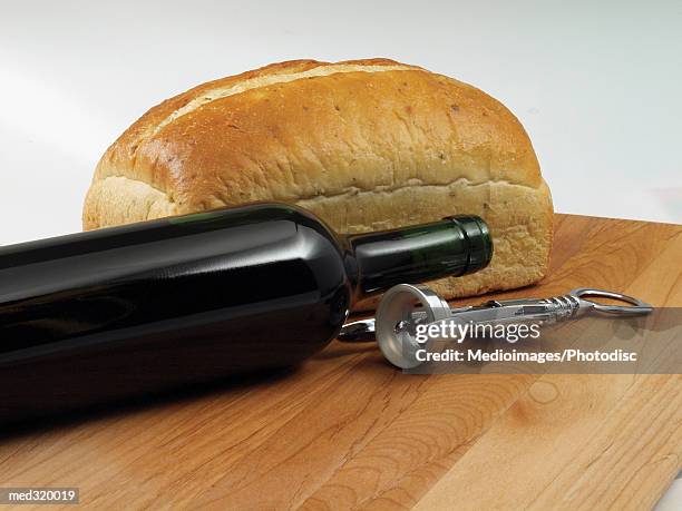 a bottle of wine with an opener and a loaf of bread - loaf stock pictures, royalty-free photos & images