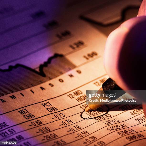 hand holding a pen, encircling numbers on paper - marked sheet of paper imagens e fotografias de stock