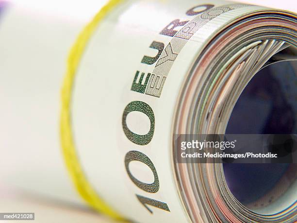 a rolls of euro bank notes with a rubber band - rubber band stockfoto's en -beelden