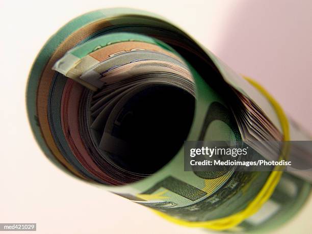 a rolls of euro bank notes with a rubber band - rubber band stockfoto's en -beelden