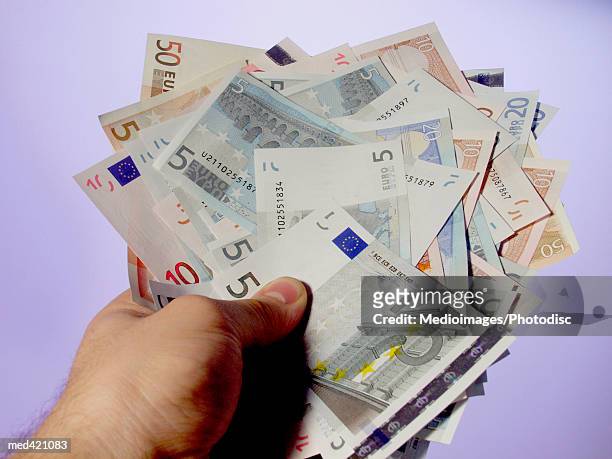 euro bank notes held by a human hand - 50 euros stock-fotos und bilder
