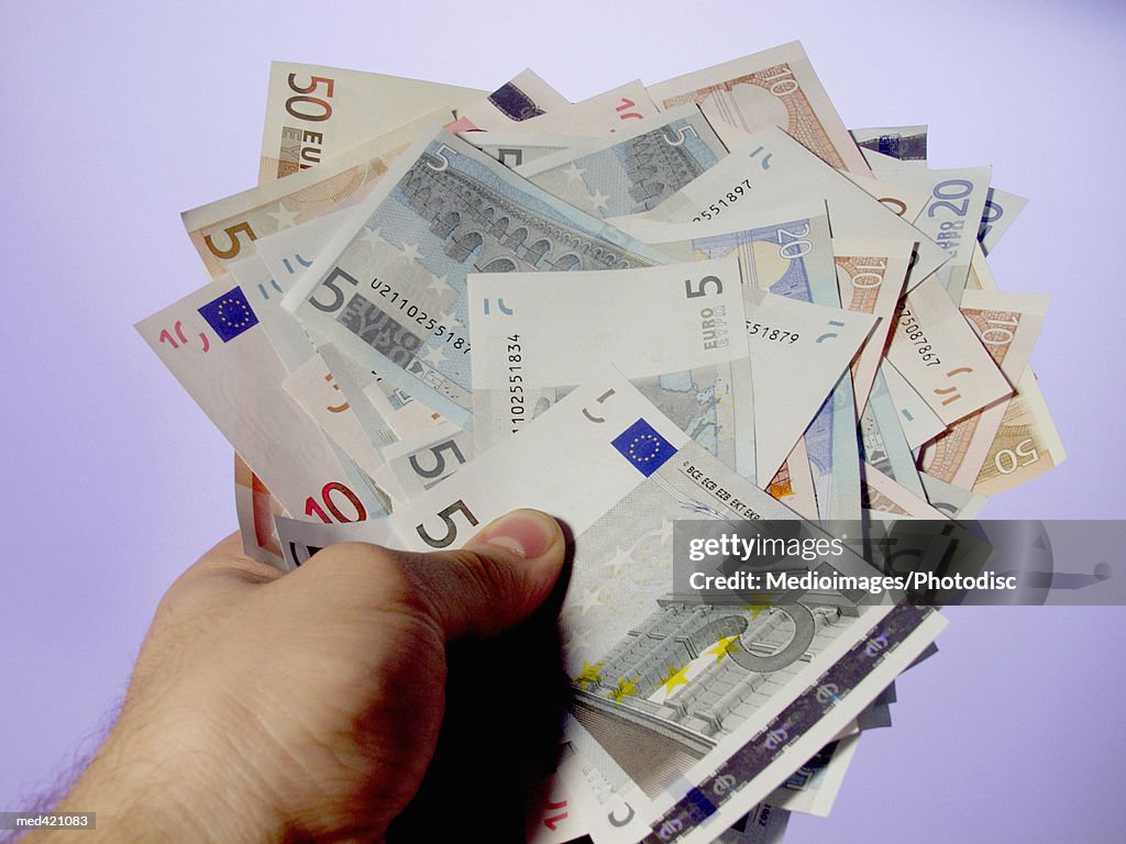 Euro bank notes held by a human hand