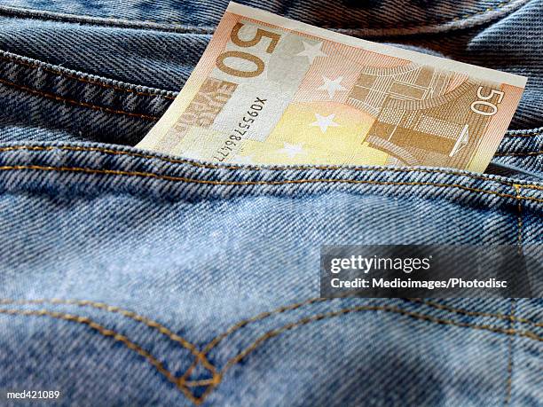 euro bank note in a person's back jeans pocket - 50 euros stock-fotos und bilder