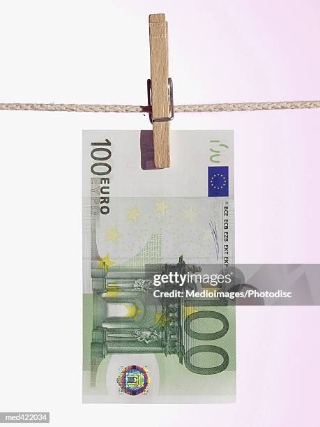 a euro bank note hung on a clothes line with a clothes peg - nota de cem euros - fotografias e filmes do acervo