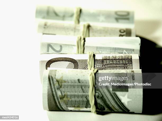 euro bank notes bound with rubber band - rubber band stockfoto's en -beelden