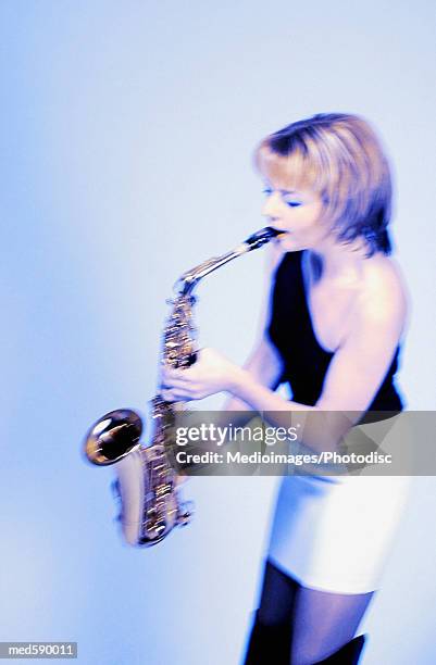 woman playing a saxophone - bläser stock-fotos und bilder