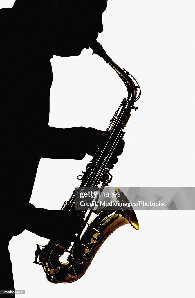 Silhouette of man playing a saxophone