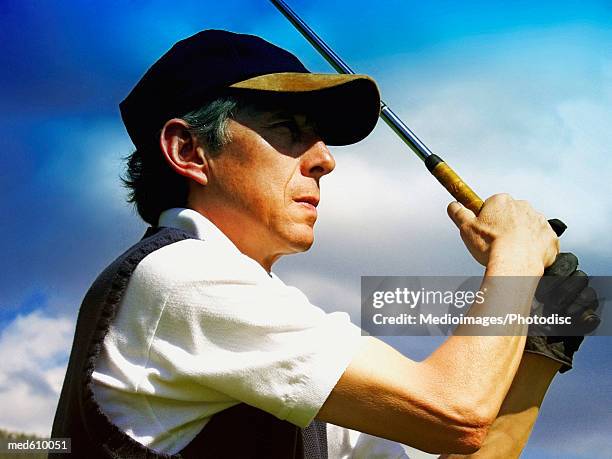 profile of golfer after swinging club, close-up - follow through stock pictures, royalty-free photos & images