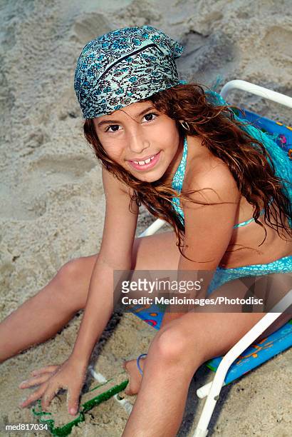 high angle view of a young girl sitting on the beach - foulard vent photos et images de collection