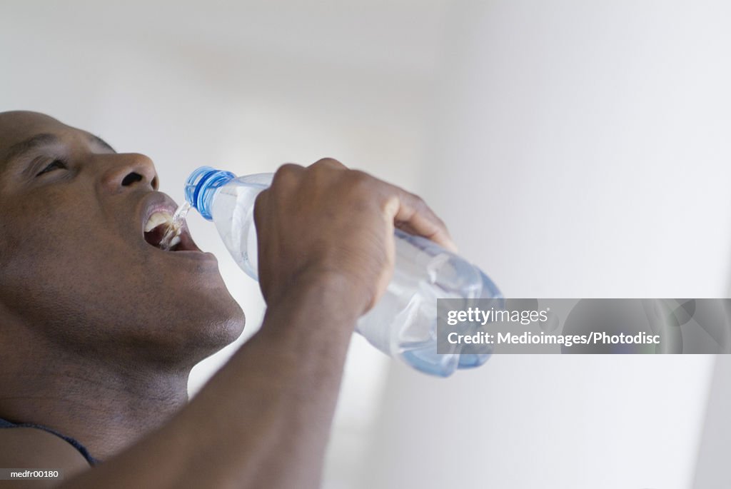 Man pouring water into mouth, close-up