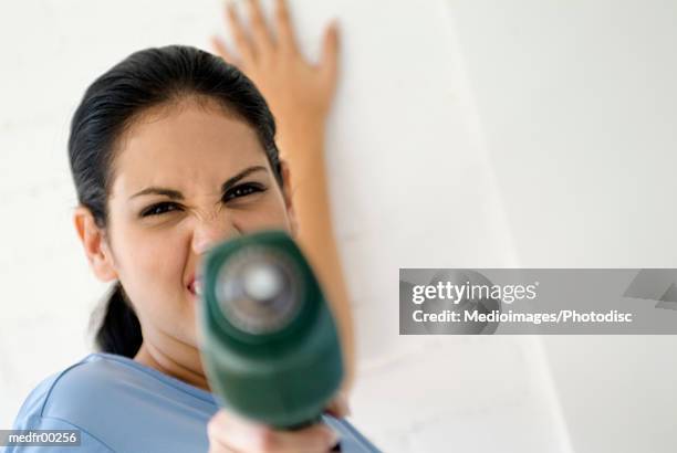 woman holding drill - grimacing stock pictures, royalty-free photos & images