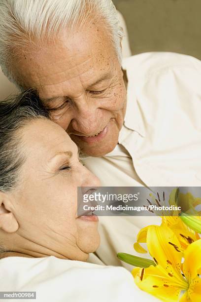 smiling senior couple with flowers, close-up - lili gentle fotografías e imágenes de stock