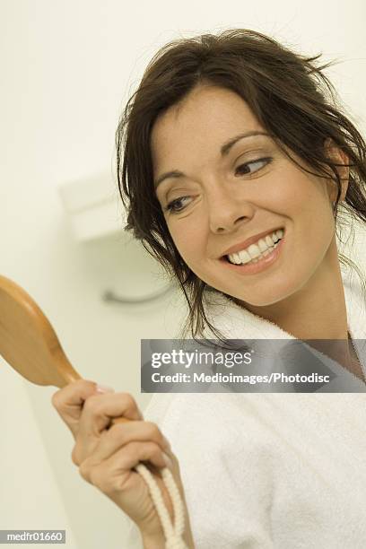 young woman holding a compact mirror and smiling - compact mirror stockfoto's en -beelden