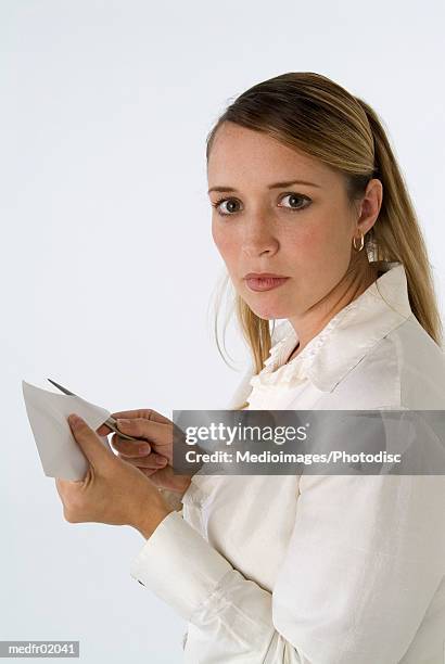 woman in frilly blouse opening a letter with a letter opener - abrecartas fotografías e imágenes de stock