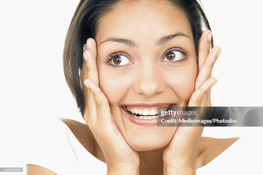 Portrait of a young woman holding her face in surprise