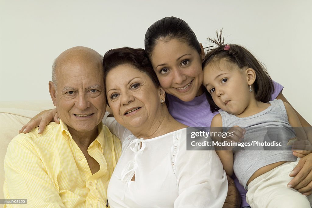 Portrait of grandparents with their daughter and granddaughter