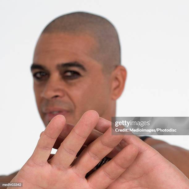 portrait of man with shaved head with arms outstretched in stop gesture, close-up, selective focus, focus on hands - shaved head ストックフォトと画像