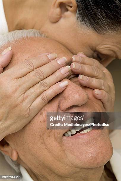 senior woman covering eyes of a senior man - over 80 個照片及圖片檔