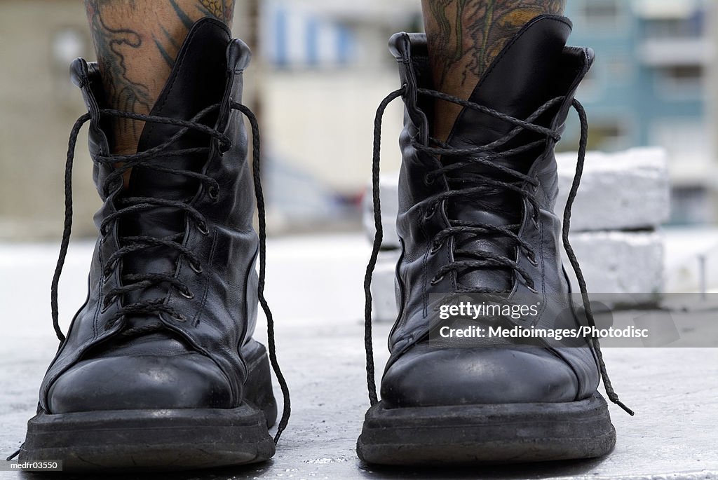 wait archive tool A Person With Tattooed Legs Wearing Black Boots High-Res Stock Photo -  Getty Images