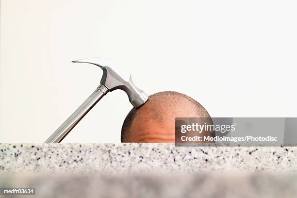 hammer on top of man's shaved head, close-up - shaved head ストックフォトと画像