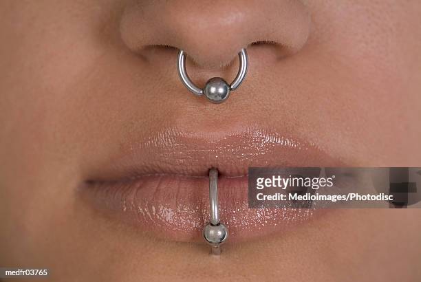 close-up of a woman's nose and mouth with piercing - nose piercing - fotografias e filmes do acervo