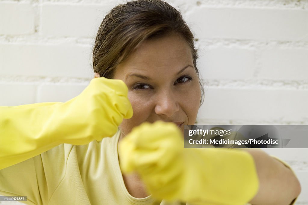 Woman wearing rubber gloves showing clenched fists