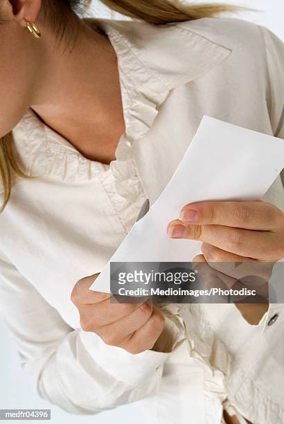 woman in frilly blouse opening a letter with a letter opener, close-up - abrecartas fotografías e imágenes de stock