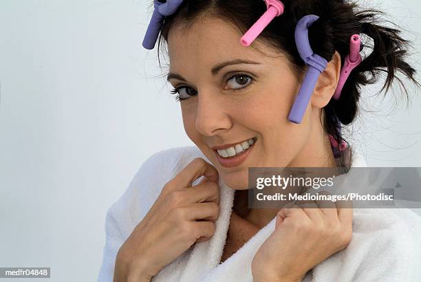 smiling mid adult woman with curlers in hair, close-up - hair curlers stockfoto's en -beelden